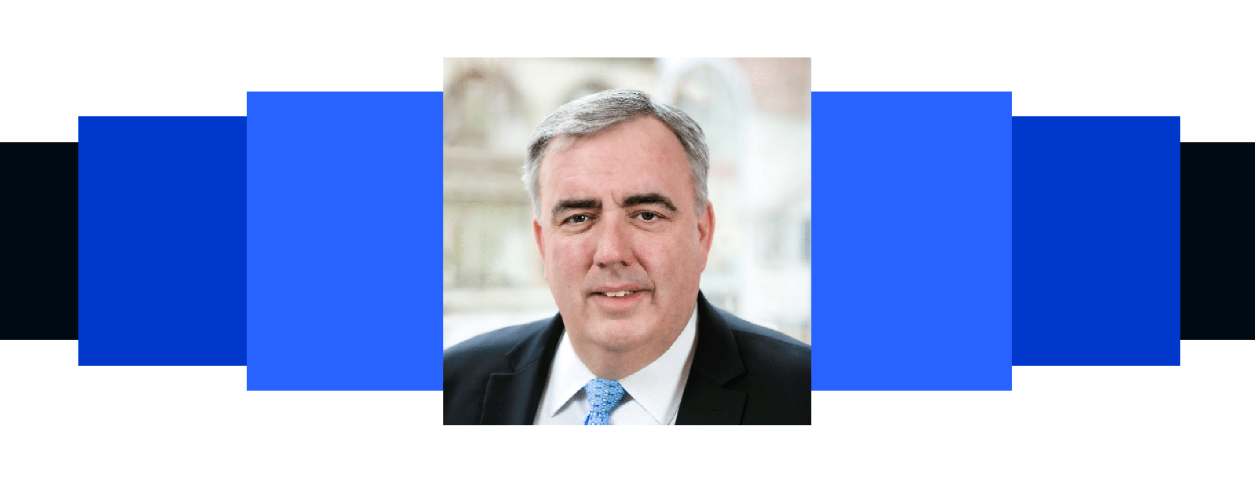 Headshot of Ed Davis, in black suit and blue tie.