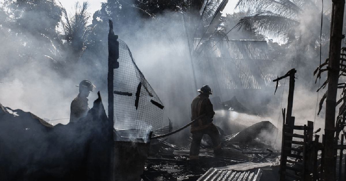 fire fighters putting out a fire on a burnt building