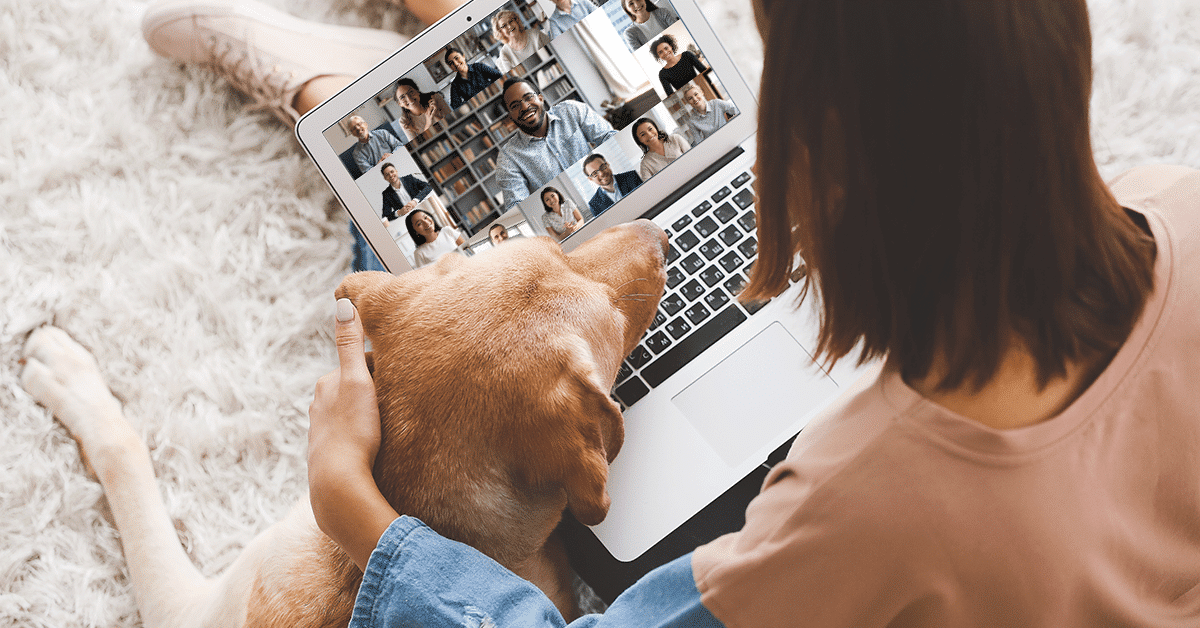 a woman on a video meeting and sitting with her dog