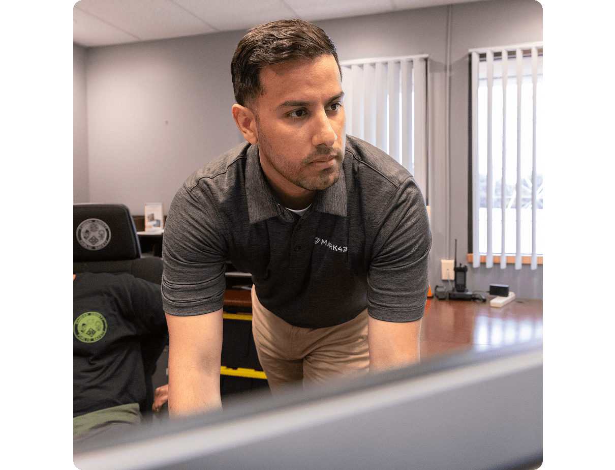 a Mark 43 team member working on the police officers computer