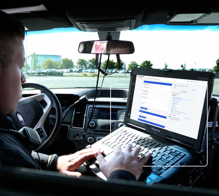 a police officer using his laptop in his patrol vehicle