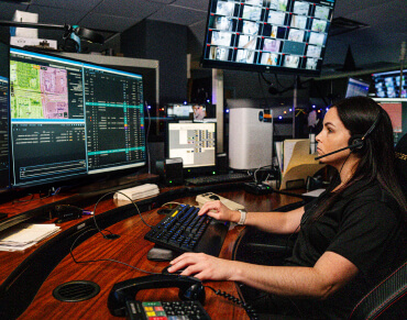 dispatch team member working on her computer screens and wearing a headset