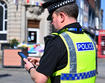A London England police officer using a smart phone