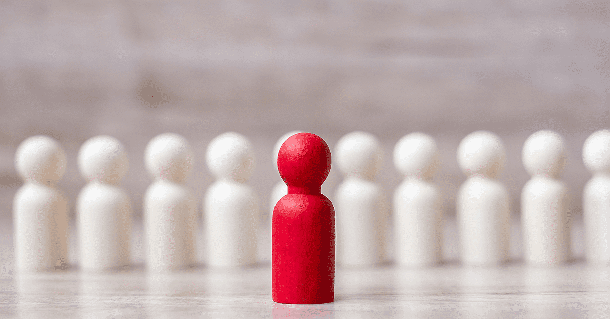 a red wooden figure with white ones behind it